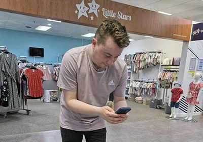 Young man shopping for children's clothes at Little Stars store in the UK.