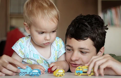 Two children playing with colourful toy cars, engaging in educational and fun activities.