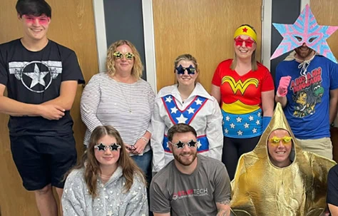 Brightly dressed children and adults in superhero and star-themed costumes for fun event.