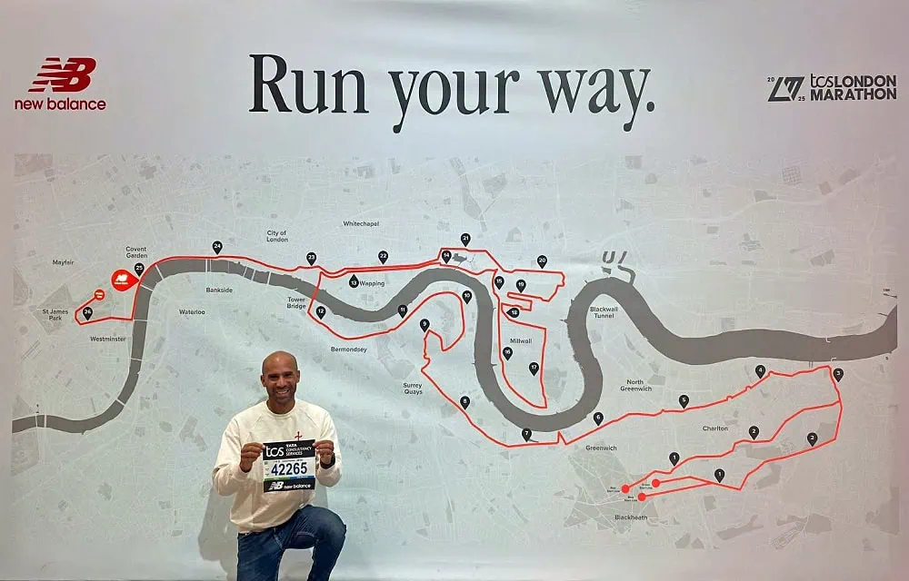 A marathon runner holding a race number in front of a detailed London marathon route map.