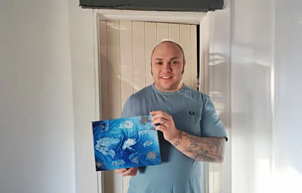 Beautiful image of a happy dad holding a unique blue artwork, celebrating fatherhood and family moments.