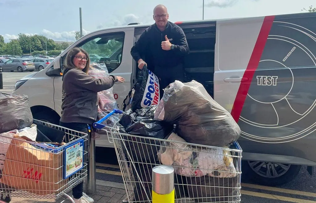 Happy woman and man at supermarket donation point.
